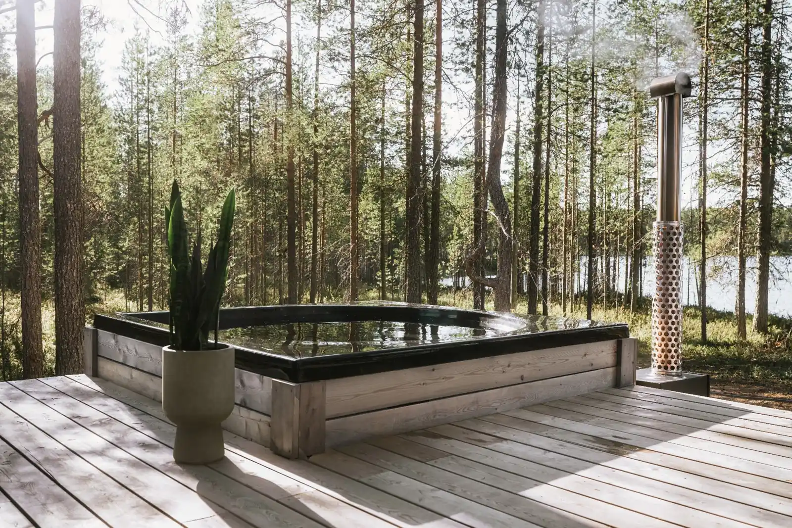 Drop Design Spa, svart bad på trädäck bland tallar vid sjön, ett av baden vi levererar till Gävle