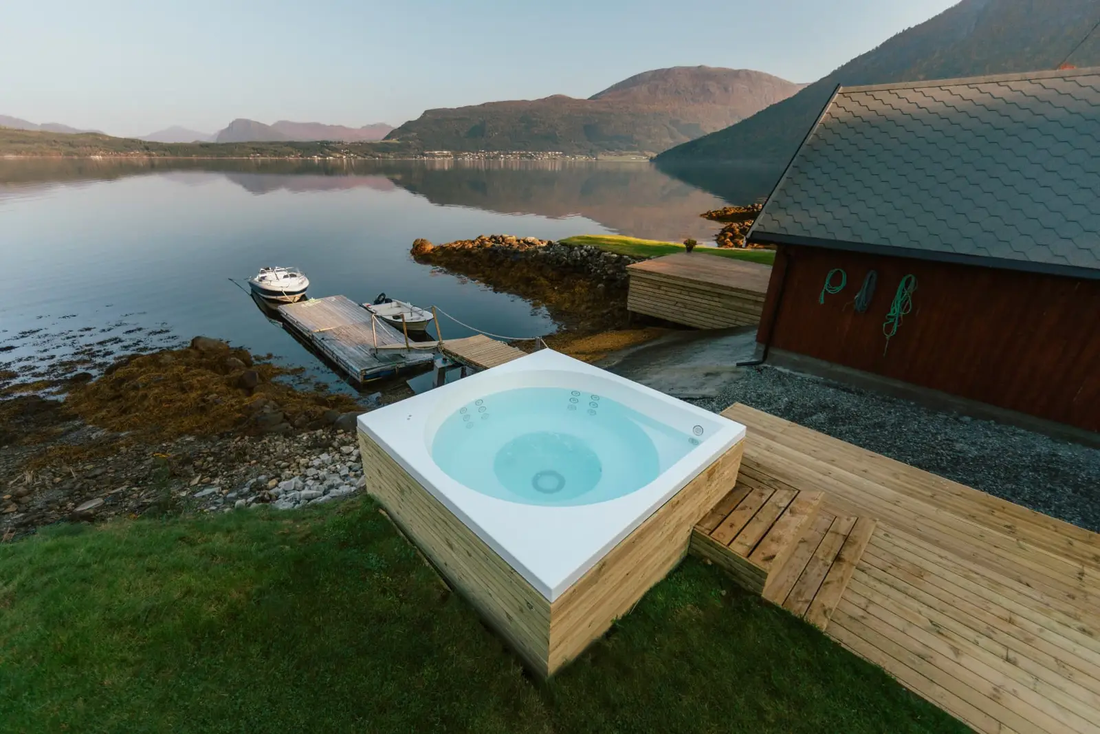 Drop Design Spa, vitt bad med trädäck vid en fjord, ett av baden vi levererar till Jönköping