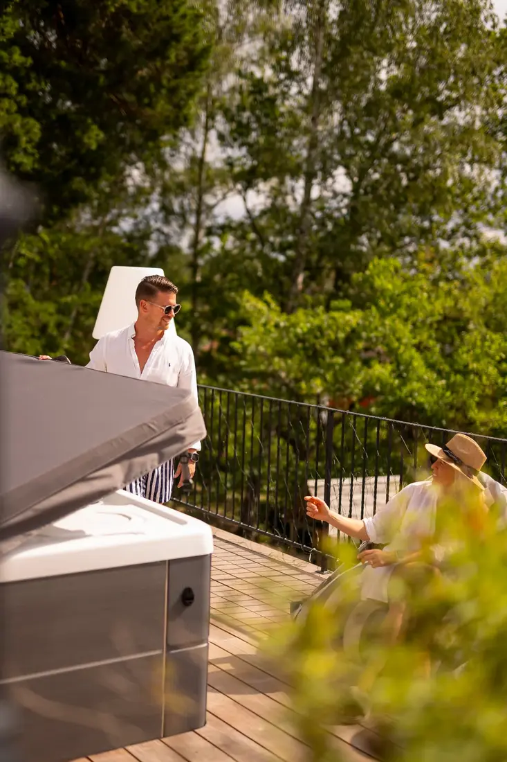 Man öppnar spalocket på ett HotSpring spabad en sommardag