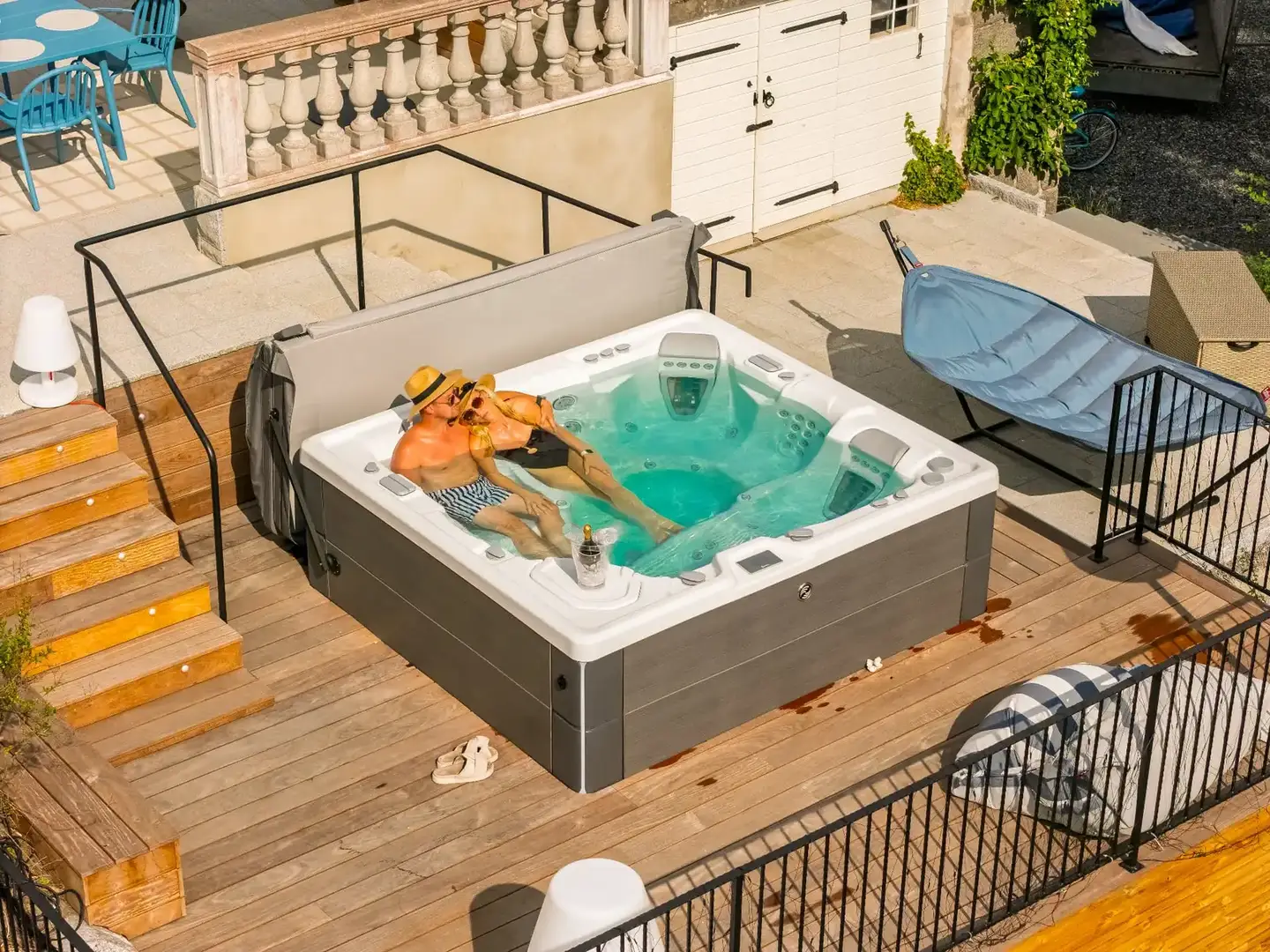 Par badar i ett HotSpring spabad på trädäck, sett ovanifrån en sommardag