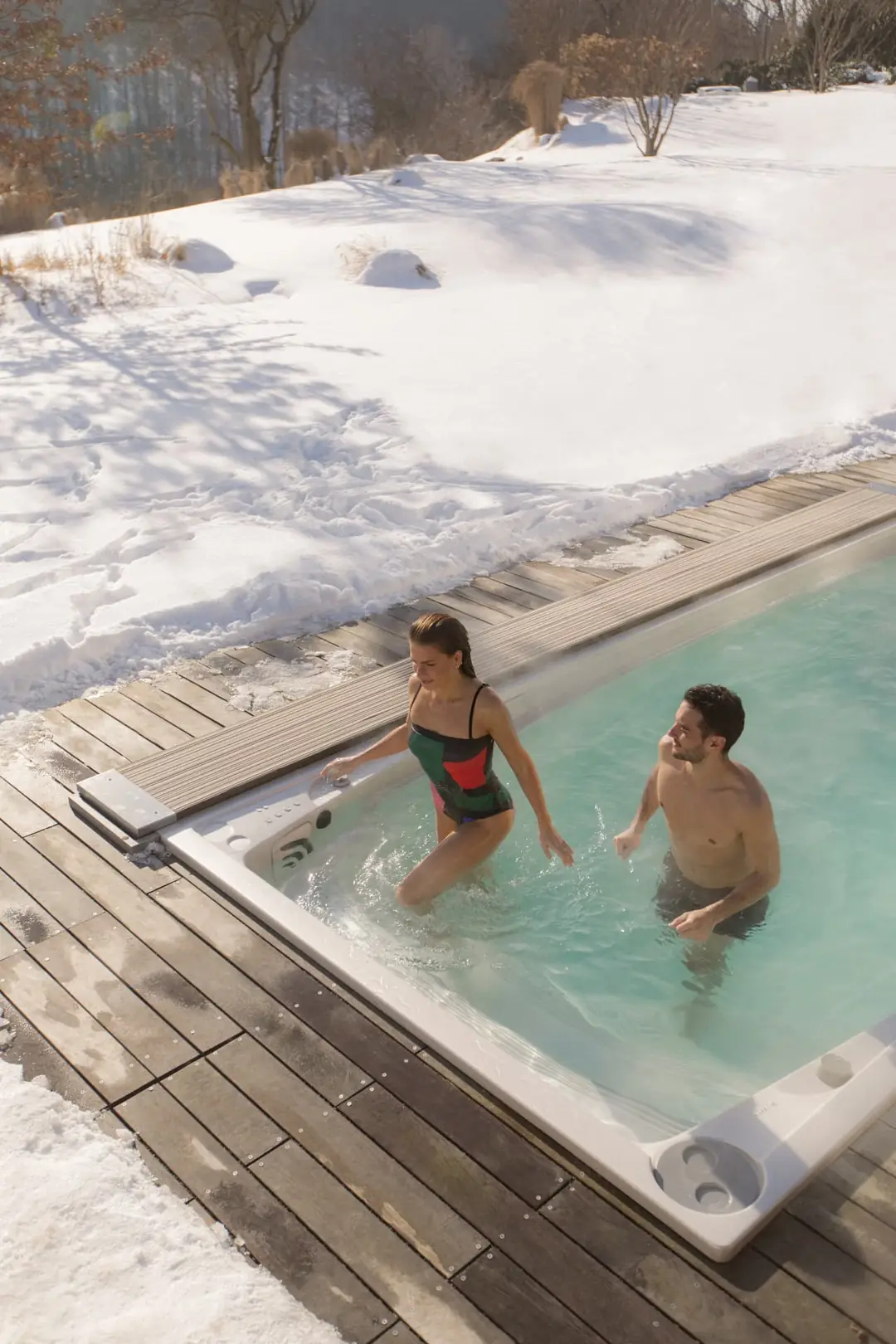 Par badar i USSPA swimspa i snötäckt trädgård