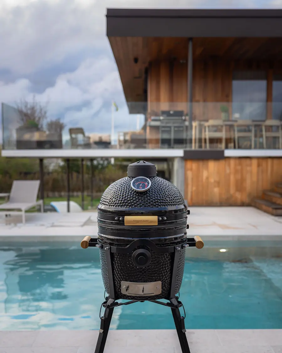 Svart KAMADO SUMO Classic Junior keramikgrill vid en pool