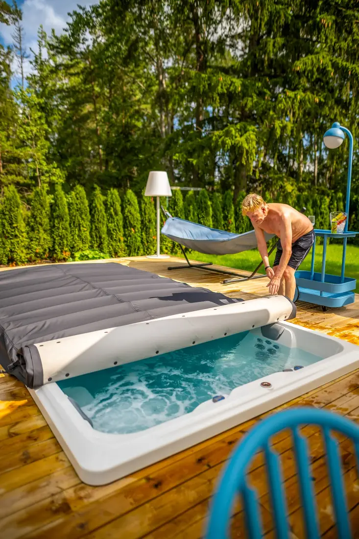 Man rullar av locket från ett Endless Pools swimspa