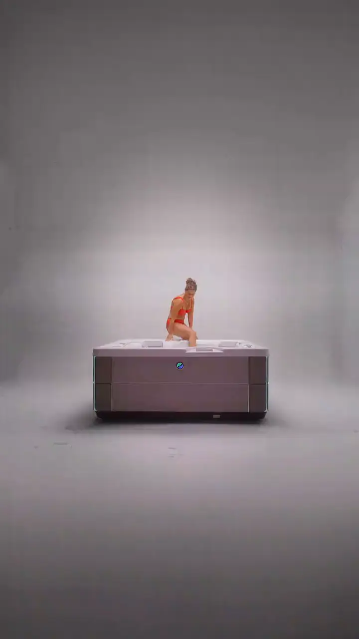 Familj badar i ett HotSpring Highlife spabad på en altan en höstkväll