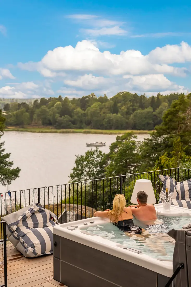 Par badar i ett HotSpring spabad med utsikt över sjön en sommardag